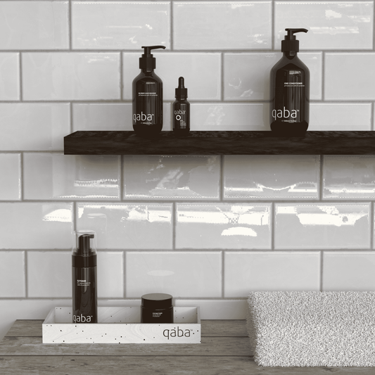 qaba haircare products, including conditioner and hair treatments, displayed in a modern bathroom, representing products used in the method of washing hair with only conditioner, as discussed in the blog post